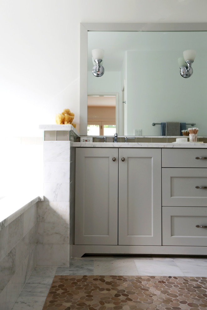 Inspiration for a large traditional master bathroom in San Diego with furniture-like cabinets, grey cabinets, marble benchtops, white tile, stone tile, a drop-in tub, a corner shower, a two-piece toilet, an undermount sink, white walls and pebble tile floors.