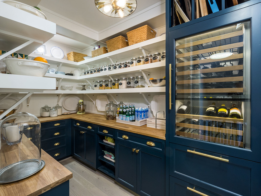 Inspiration for a country u-shaped kitchen pantry in Portland with open cabinets, blue cabinets, wood benchtops, white splashback, light hardwood floors, no island, beige floor and panelled appliances.