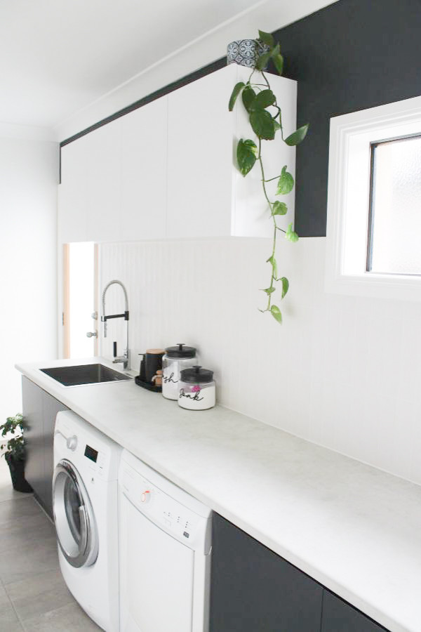 Inspiration for a mid-sized single-wall utility room in Perth with a drop-in sink, raised-panel cabinets, white cabinets, copper benchtops, ceramic splashback, white walls, porcelain floors, a side-by-side washer and dryer, grey floor and multi-coloured benchtop.