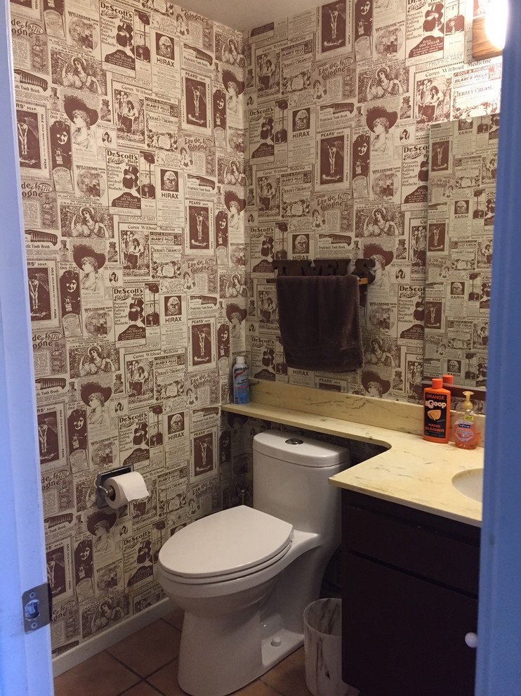 Photo of a small eclectic powder room in Los Angeles with flat-panel cabinets, dark wood cabinets, a one-piece toilet, ceramic floors and brown floor.