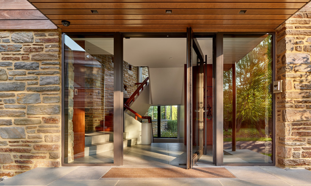 Retro Eingang mit Porzellan-Bodenfliesen, Drehtür, Haustür aus Glas, grauem Boden und Holzdecke in Philadelphia