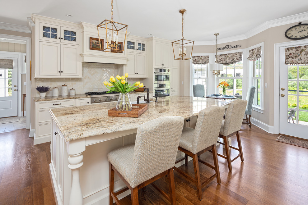 This is an example of a traditional galley eat-in kitchen in Boston with a farmhouse sink, beaded inset cabinets, beige cabinets, beige splashback, stainless steel appliances, dark hardwood floors, with island, brown floor and brown benchtop.