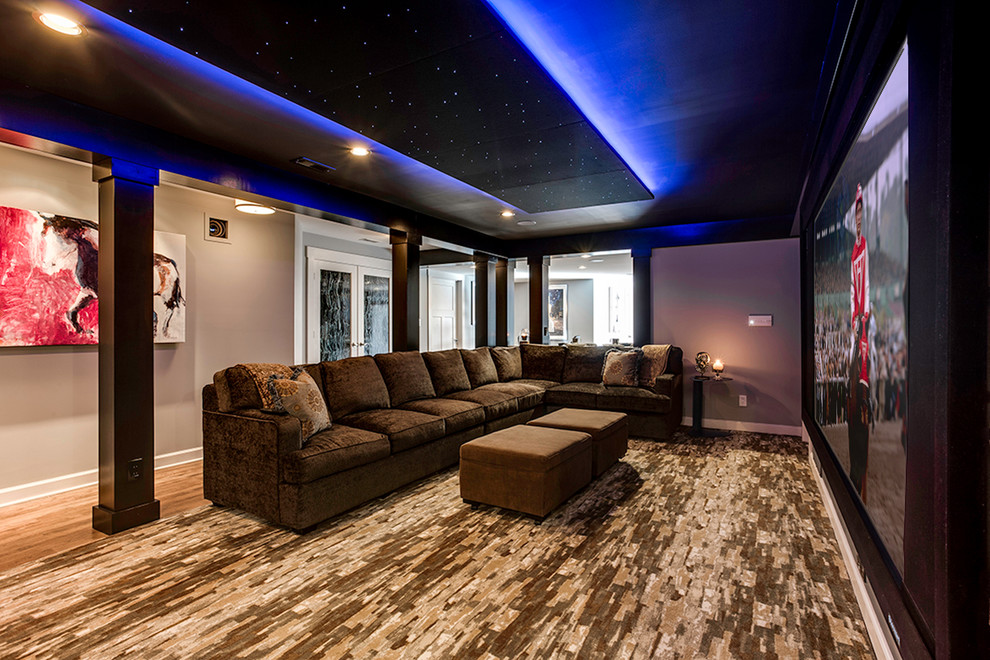 Expansive contemporary open concept home theatre in Baltimore with beige walls, carpet and a projector screen.