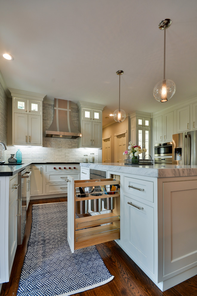 Large transitional u-shaped dark wood floor and brown floor eat-in kitchen photo in Chicago with an undermount sink, recessed-panel cabinets, white cabinets, soapstone countertops, gray backsplash, marble backsplash, stainless steel appliances and an island