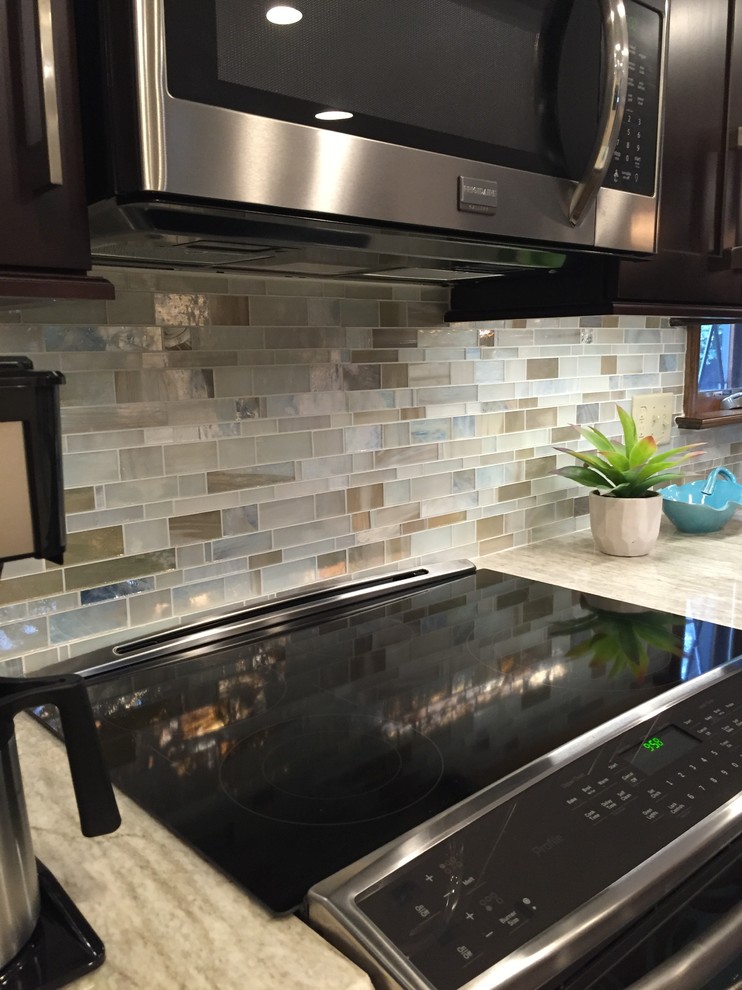Inspiration for a transitional ceramic tile kitchen remodel with a single-bowl sink, dark wood cabinets, multicolored backsplash, mosaic tile backsplash, stainless steel appliances and an island