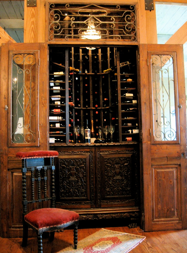 Small mediterranean wine cellar in Charlotte with light hardwood floors and diamond bins.