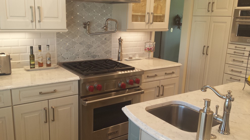 Inspiration for a small transitional u-shaped ceramic tile eat-in kitchen remodel with an undermount sink, raised-panel cabinets, white cabinets, marble countertops, white backsplash, subway tile backsplash, stainless steel appliances and an island