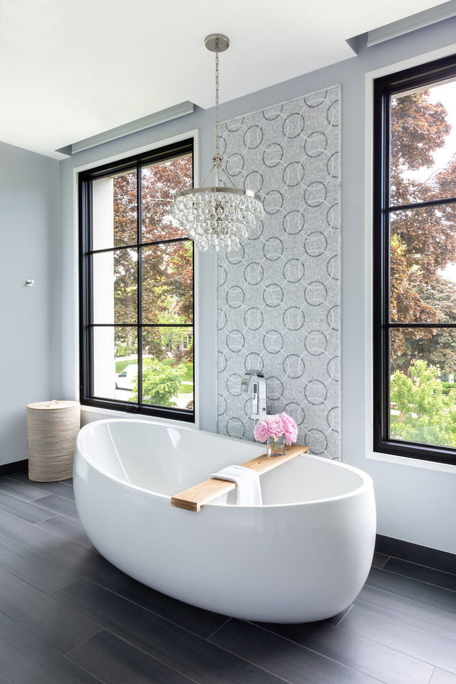 Inspiration for a transitional bathroom in Milwaukee with a freestanding tub, grey walls and brown floor.