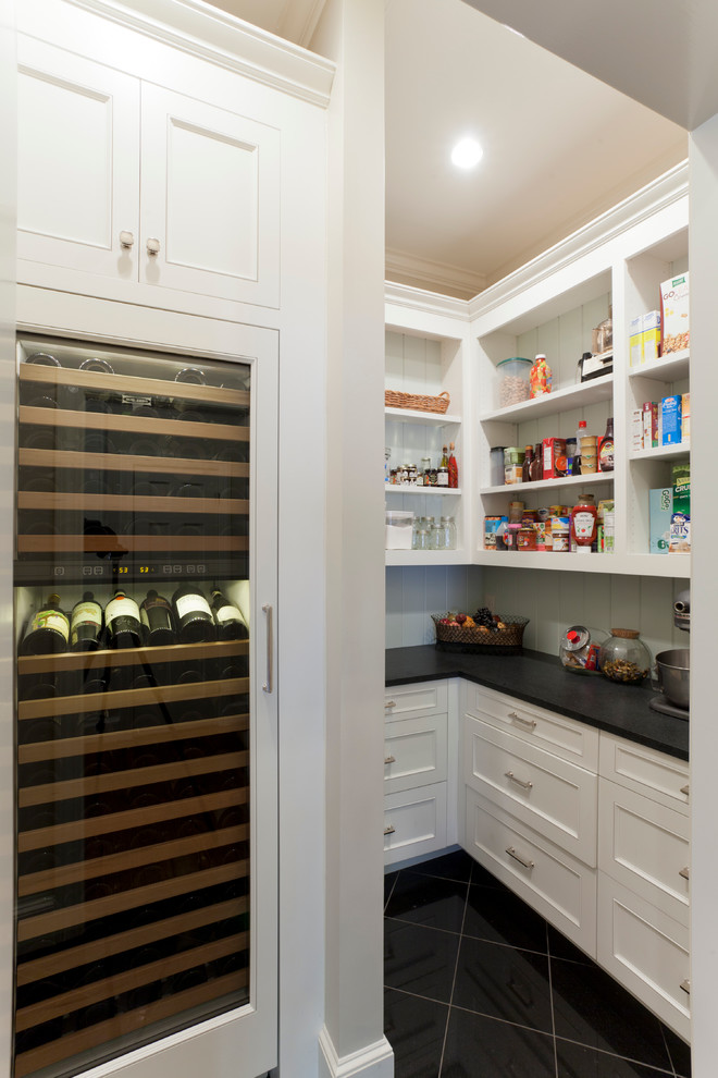 This is an example of a traditional kitchen pantry in Charlotte with recessed-panel cabinets, white cabinets and white splashback.