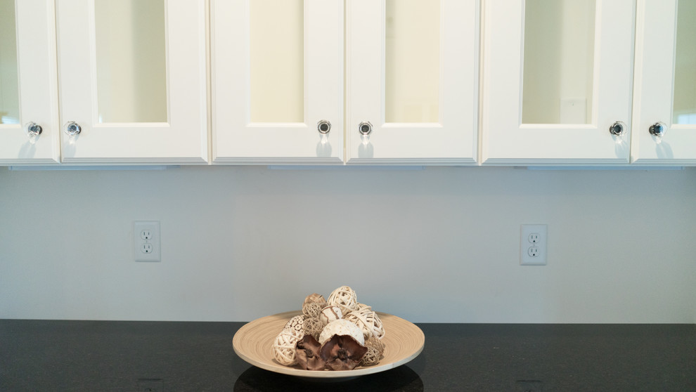 Open concept kitchen - mid-sized transitional l-shaped dark wood floor open concept kitchen idea with an undermount sink, shaker cabinets, white cabinets, granite countertops, gray backsplash, stainless steel appliances and an island