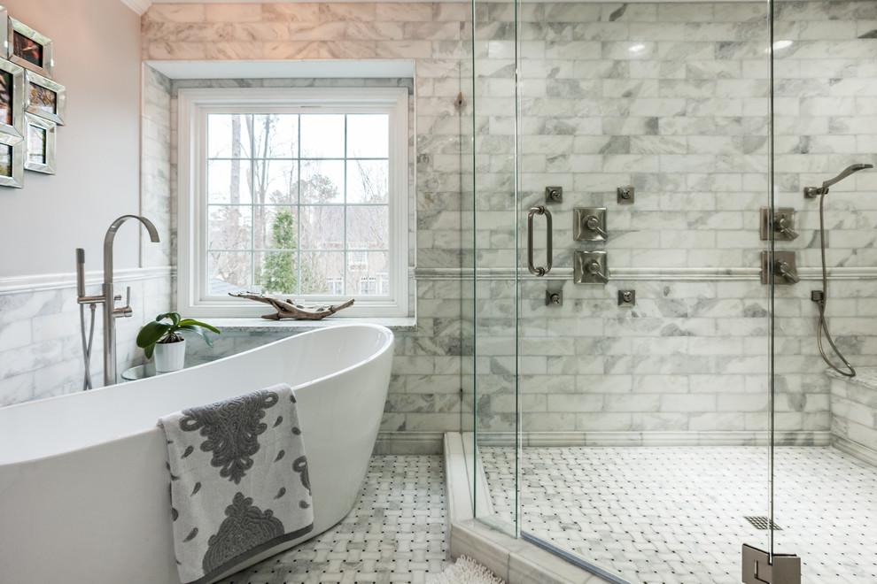 Inspiration for a transitional master bathroom in Raleigh with a freestanding tub, a double shower, gray tile, white tile, marble floors and a hinged shower door.