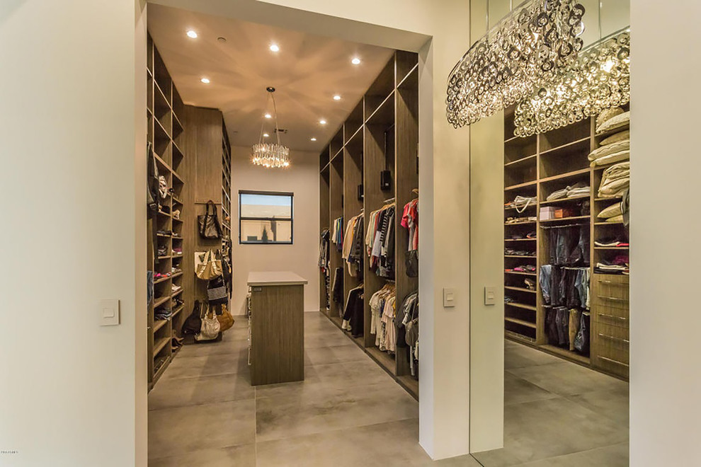 Photo of a large contemporary gender-neutral walk-in wardrobe in Phoenix with flat-panel cabinets, light wood cabinets and concrete floors.