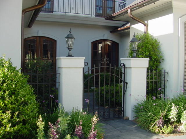This is an example of a mid-sized mediterranean two-storey white exterior in New Orleans.