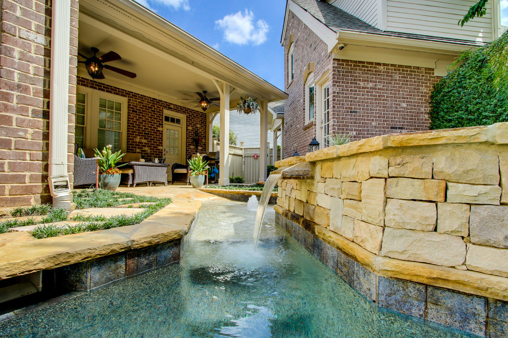 Inspiration for a mid-sized transitional backyard patio in Atlanta with natural stone pavers and a roof extension.