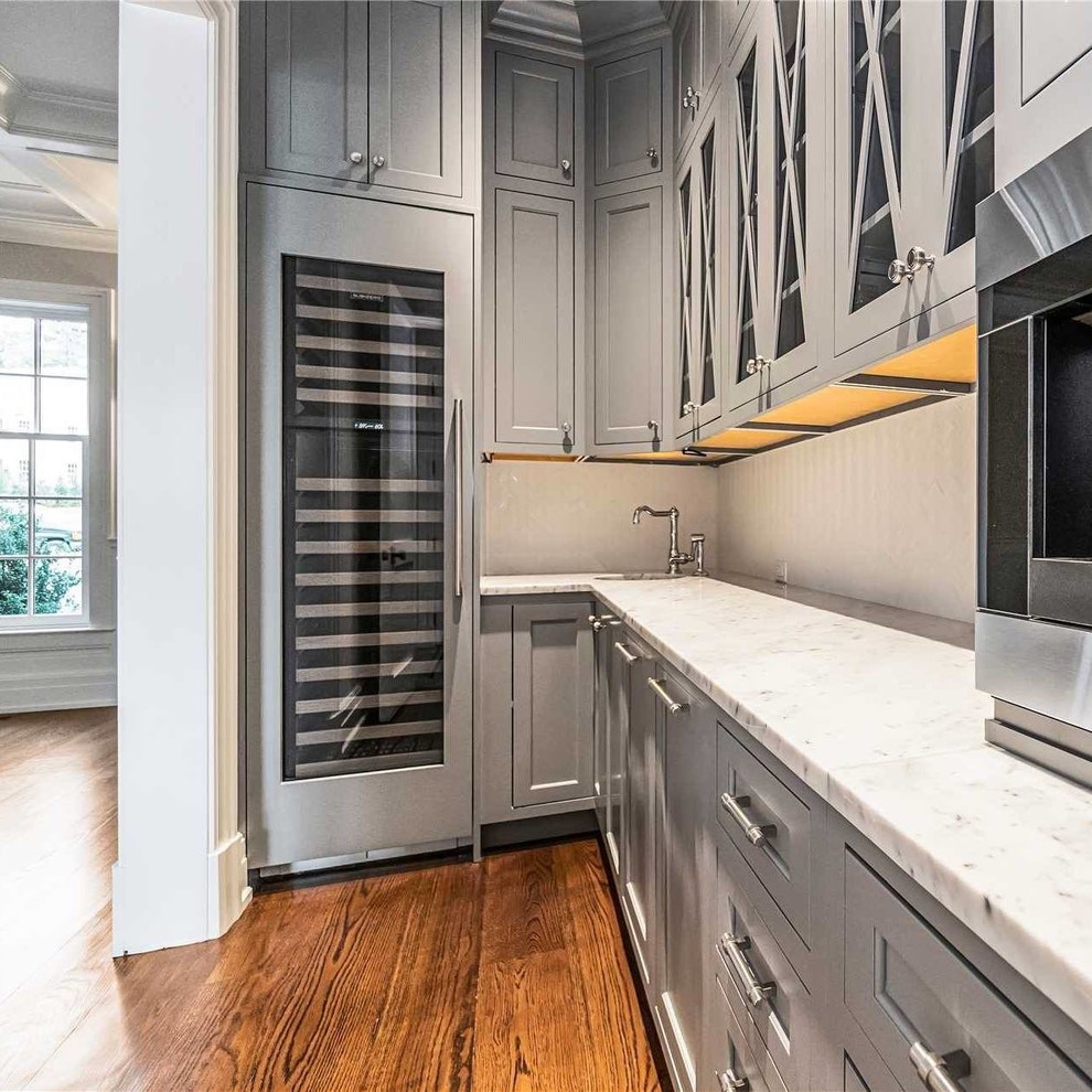 Inspiration for a large transitional l-shaped dark wood floor and brown floor open concept kitchen remodel with beaded inset cabinets, white cabinets, granite countertops, gray backsplash, glass tile backsplash, stainless steel appliances, an island and gray countertops