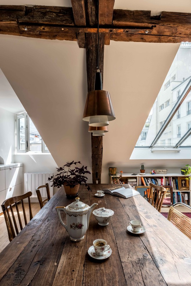 This is an example of a mid-sized contemporary open plan dining in Paris with white walls, light hardwood floors, no fireplace and beige floor.