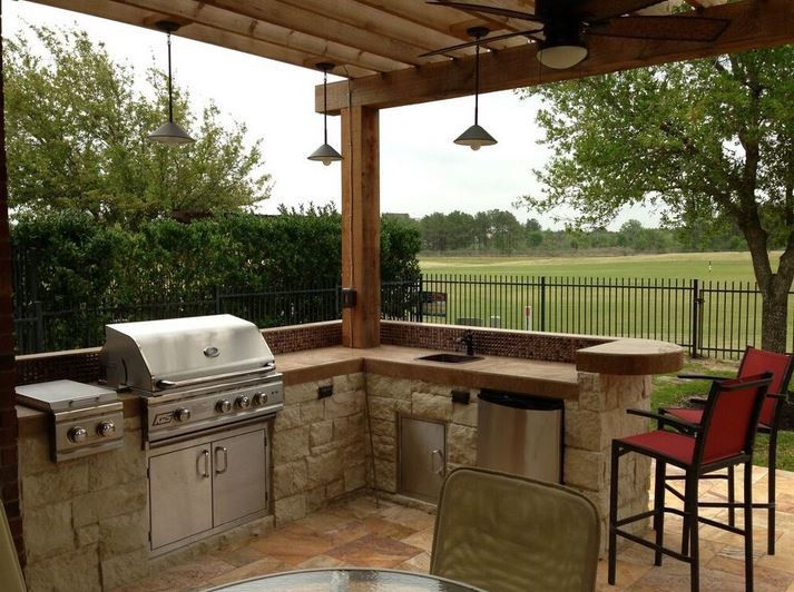Photo of a mid-sized transitional backyard patio in Houston with an outdoor kitchen, tile and a roof extension.