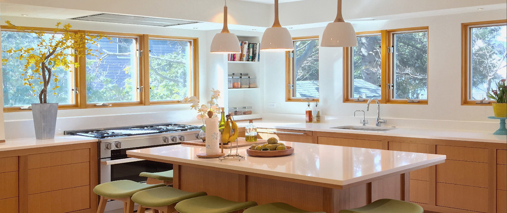 Inspiration for a large transitional l-shaped light wood floor eat-in kitchen remodel in Boston with a single-bowl sink, flat-panel cabinets, medium tone wood cabinets, quartz countertops, white backsplash, stone slab backsplash, stainless steel appliances and an island