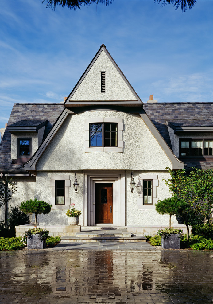 Mid-sized traditional two-storey stucco white house exterior in Detroit with a gable roof and a shingle roof.