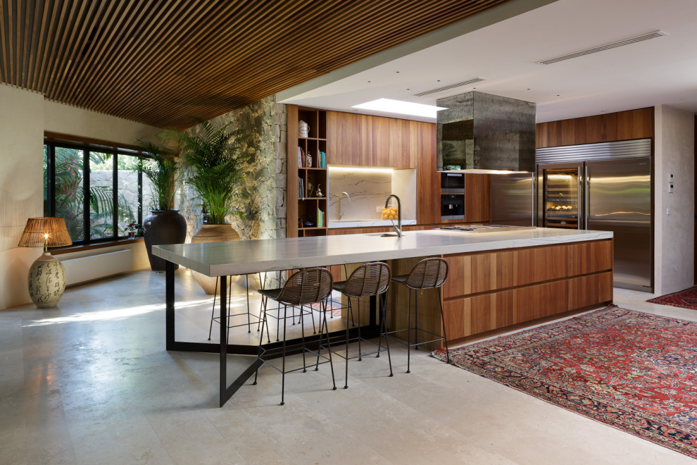 Inspiration for a midcentury l-shaped kitchen in Alicante-Costa Blanca with an undermount sink, flat-panel cabinets, medium wood cabinets, white splashback, stone slab splashback, stainless steel appliances, concrete floors, with island, grey floor and white benchtop.