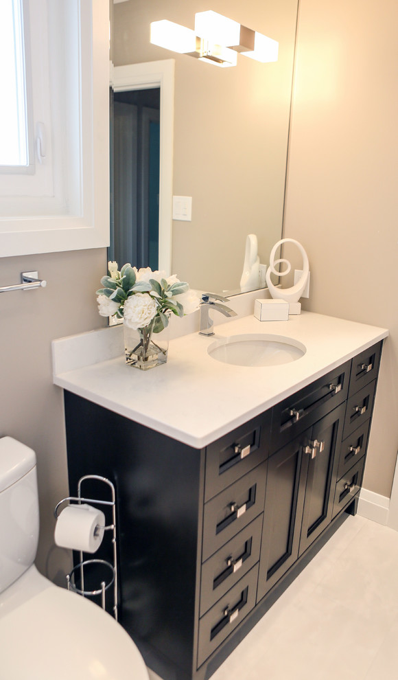 This is an example of a small transitional master bathroom in Toronto with recessed-panel cabinets, dark wood cabinets, an alcove tub, an alcove shower, a one-piece toilet, gray tile, porcelain tile, beige walls, porcelain floors, an undermount sink and quartzite benchtops.