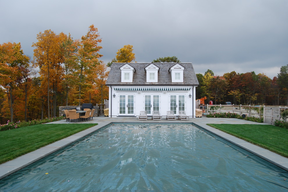 This is an example of a country backyard rectangular pool in New York with a pool house.