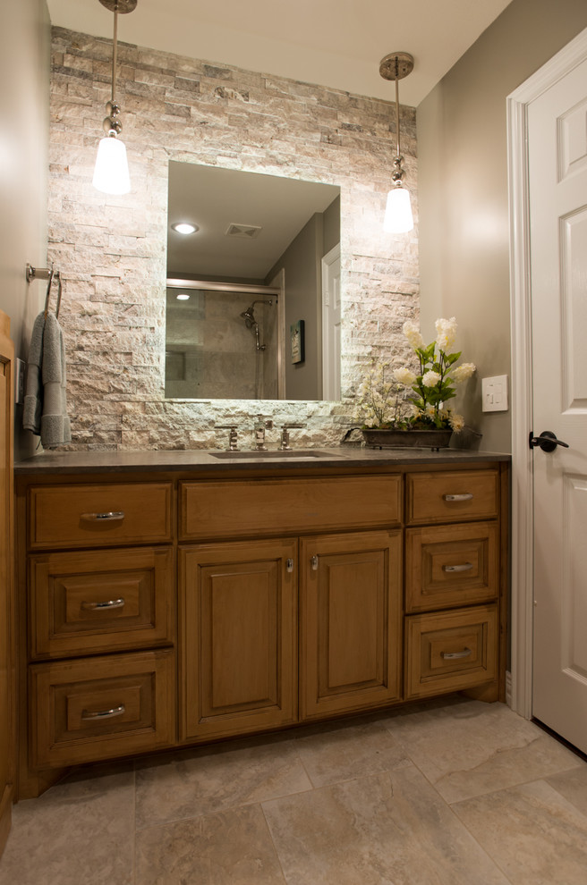 This is an example of a small transitional kids bathroom in Dallas with a drop-in sink, raised-panel cabinets, medium wood cabinets, quartzite benchtops, a shower/bathtub combo, beige tile and grey walls.