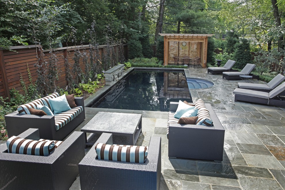 This is an example of a small contemporary backyard rectangular lap pool in Toronto with natural stone pavers.