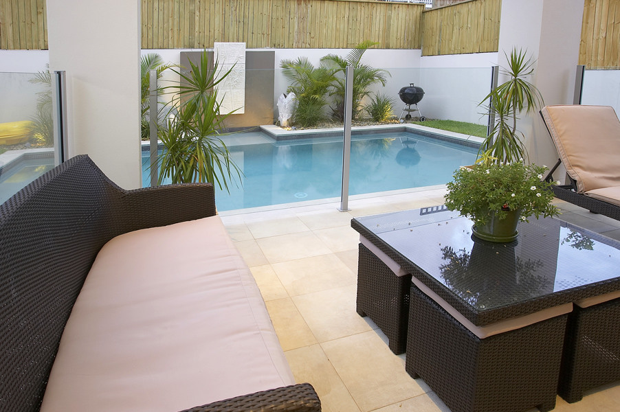 Inspiration for a mid-sized contemporary courtyard patio in Brisbane with tile, no cover and a water feature.