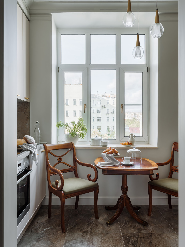 Inspiration for a mid-sized traditional galley open plan kitchen in Moscow with an undermount sink, flat-panel cabinets, beige cabinets, laminate benchtops, grey splashback, ceramic splashback, porcelain floors, grey floor and grey benchtop.