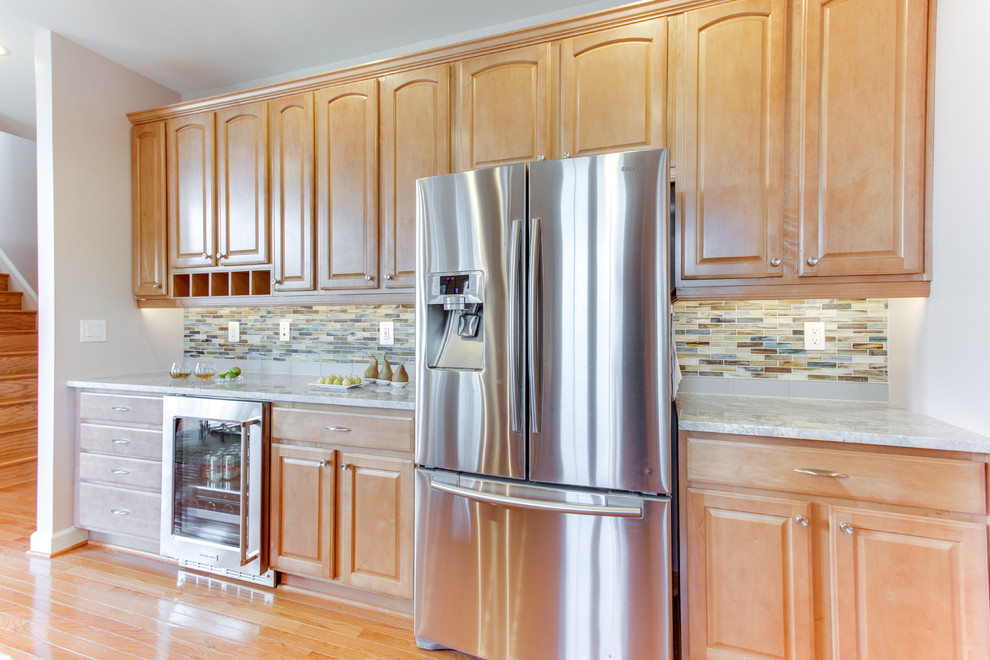 Kitchen - mid-sized transitional u-shaped medium tone wood floor kitchen idea in Baltimore with an undermount sink, raised-panel cabinets, medium tone wood cabinets, granite countertops, glass sheet backsplash, stainless steel appliances and an island