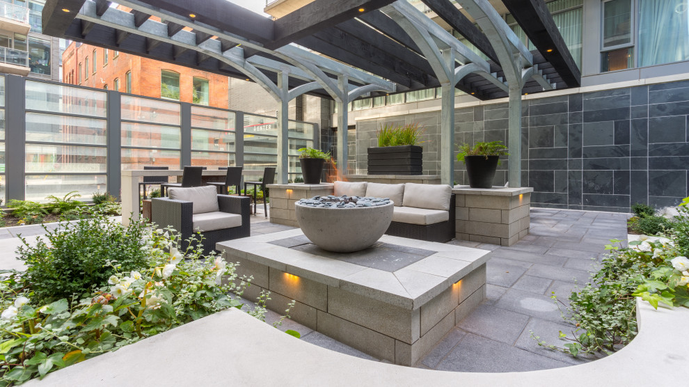 Mid-sized modern patio in Toronto with a fire feature and a pergola.