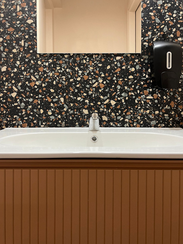 Стильный дизайн: маленькая ванная комната в стиле фьюжн с фасадами с выступающей филенкой, оранжевыми фасадами, унитазом-моноблоком, разноцветной плиткой, керамогранитной плиткой, разноцветными стенами, полом из керамогранита, накладной раковиной, разноцветным полом, белой столешницей, тумбой под одну раковину и подвесной тумбой для на участке и в саду - последний тренд