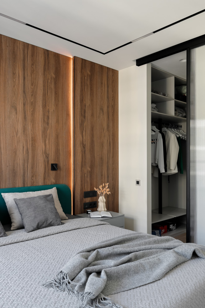 Стильный дизайн: хозяйская спальня среднего размера, в белых тонах с отделкой деревом в современном стиле с белыми стенами, светлым паркетным полом, бежевым полом, панелями на стенах и акцентной стеной - последний тренд