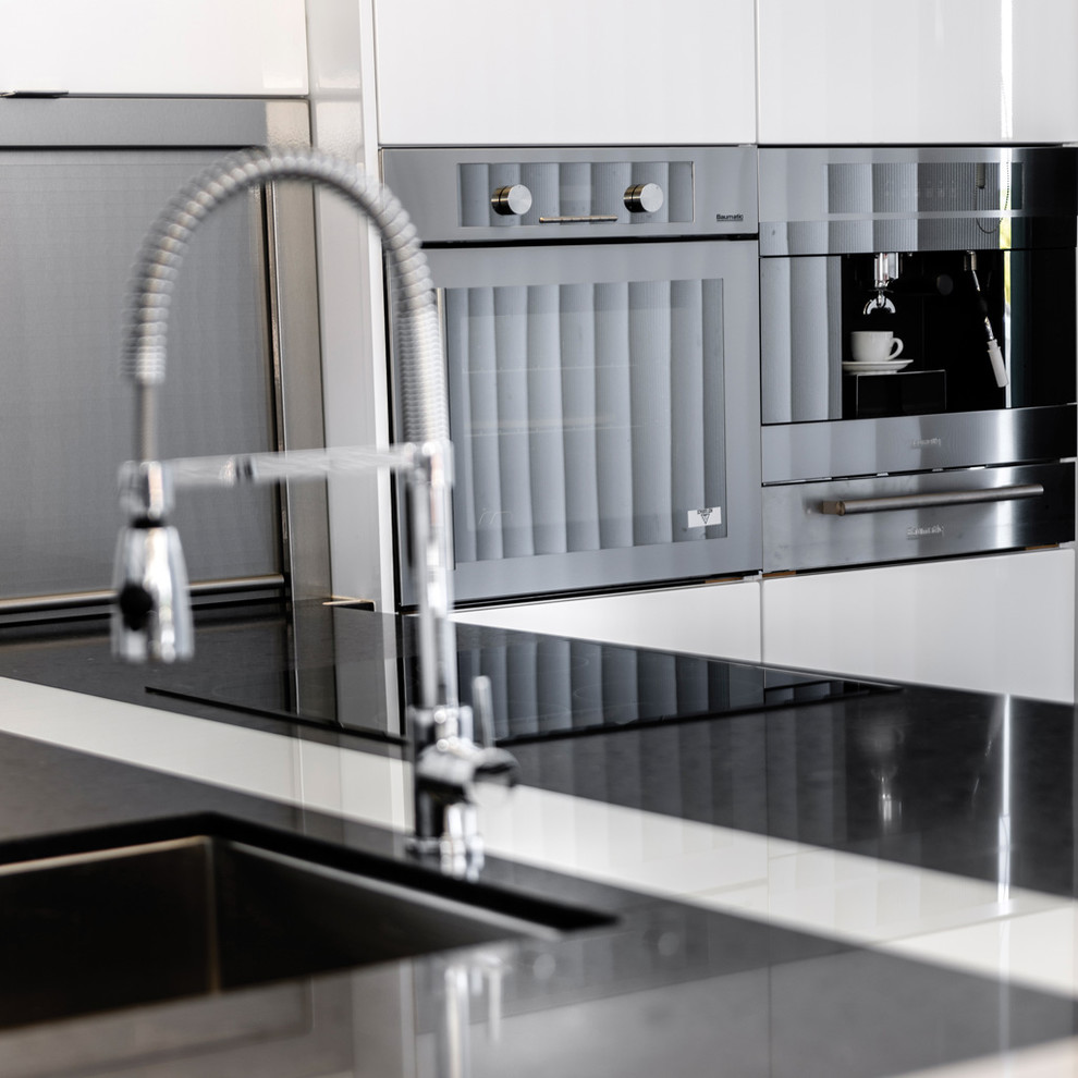 Inspiration for a mid-sized modern kitchen in Perth with an undermount sink, quartz benchtops and black appliances.