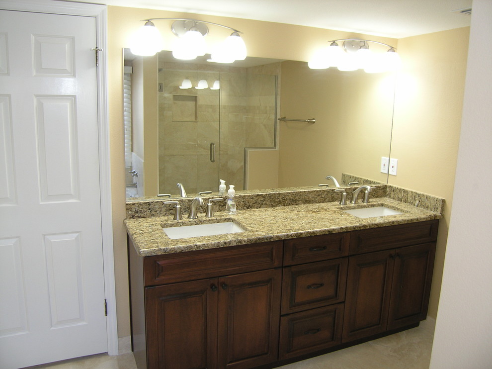 Design ideas for a mid-sized traditional master bathroom in Tampa with a corner shower, stone tile, travertine floors, granite benchtops, raised-panel cabinets, dark wood cabinets, beige walls, an undermount sink and beige floor.