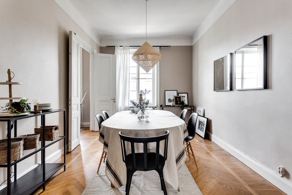 Design ideas for a mid-sized scandinavian dining room in Stockholm with grey walls and medium hardwood floors.