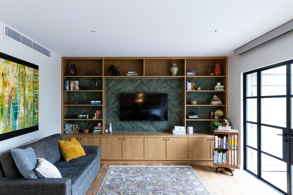 Bild på ett mellanstort funkis allrum med öppen planlösning, med gröna väggar, mellanmörkt trägolv och en väggmonterad TV