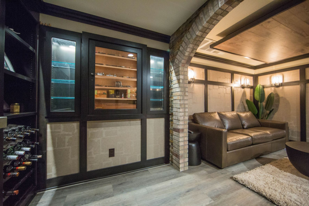 Inredning av en modern stor källare utan fönster, med en hemmabar, bruna väggar, laminatgolv, en standard öppen spis och brunt golv