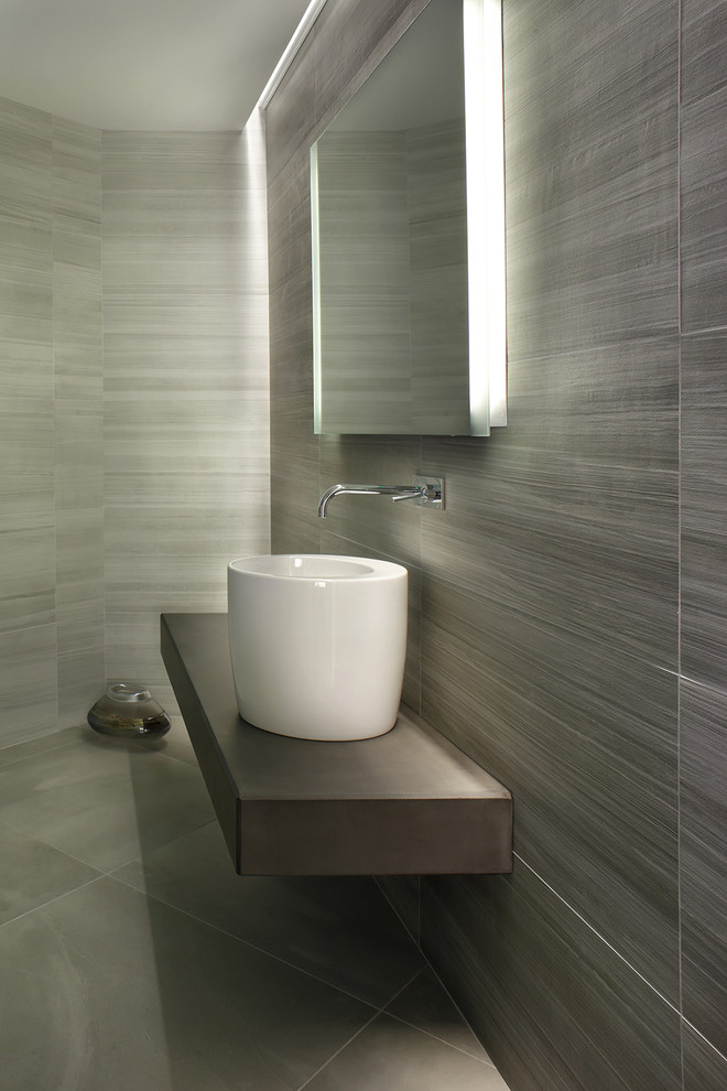 This is an example of a modern powder room in New York with a vessel sink, concrete benchtops and grey floor.