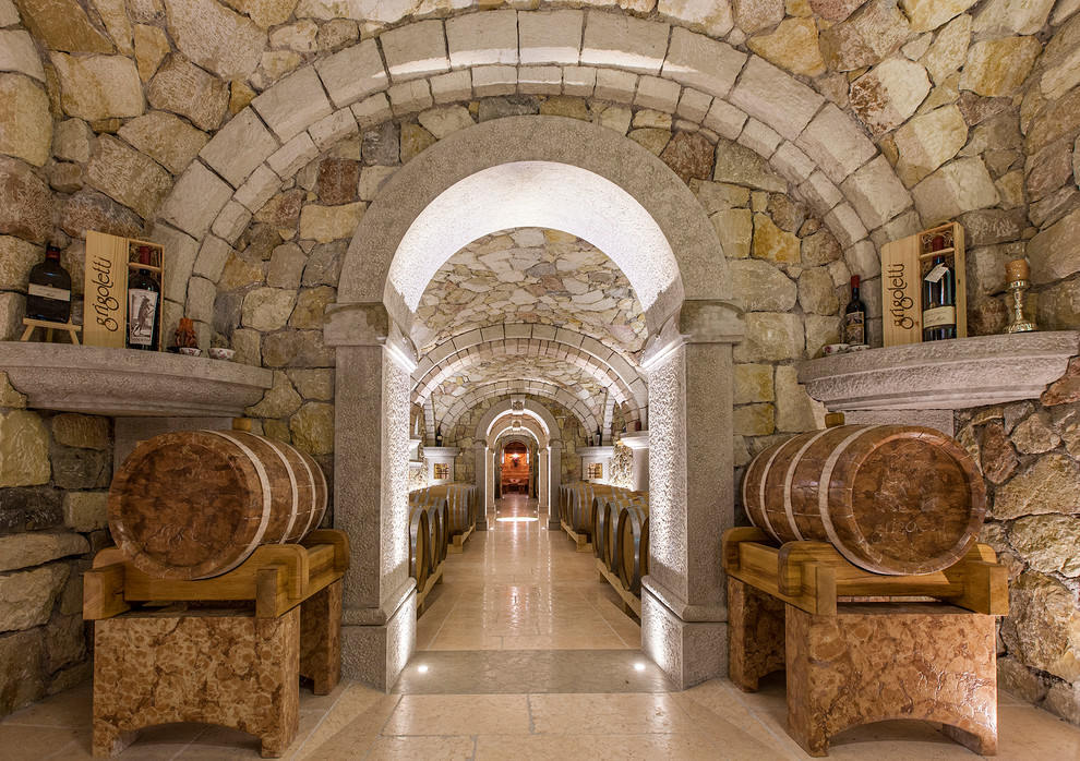 This is an example of a mid-sized country wine cellar in Other with limestone floors and pink floor.