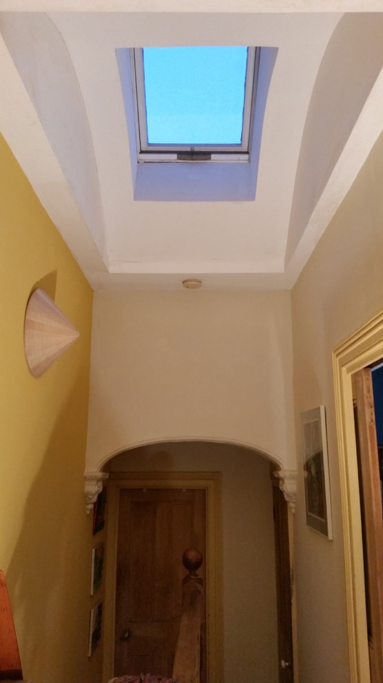 Hallway in Sydney with white walls, light hardwood floors and brown floor.