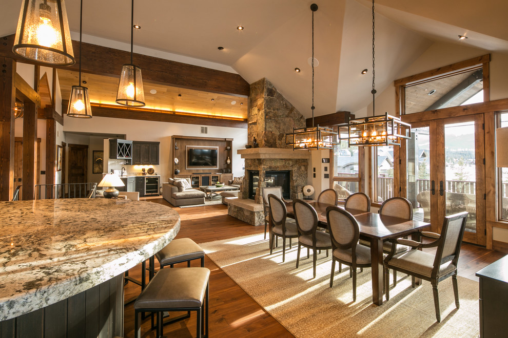 Inspiration for a large country open plan dining in Denver with brown walls, dark hardwood floors, a corner fireplace and a stone fireplace surround.