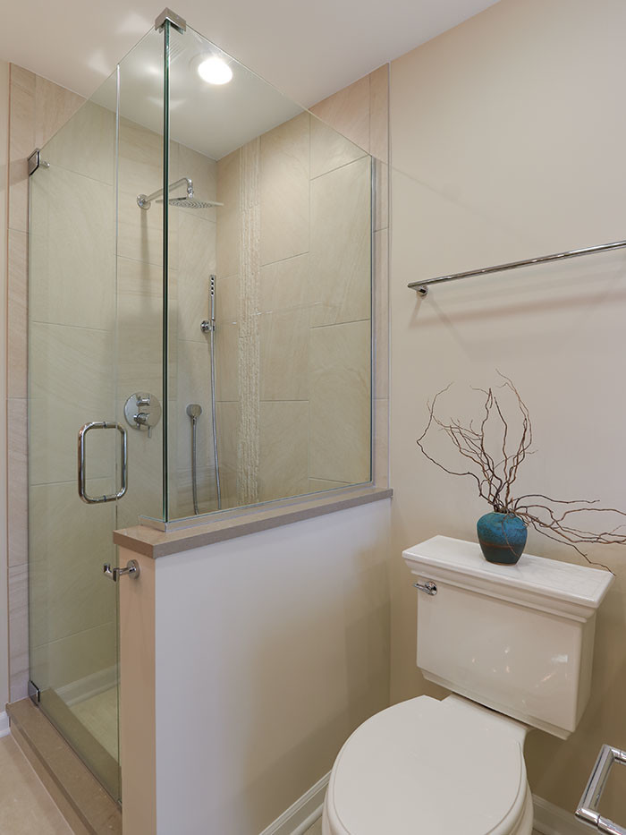 This is an example of a large country master bathroom in Chicago with beaded inset cabinets, grey cabinets, a freestanding tub, a corner shower, a two-piece toilet, beige tile, stone tile, beige walls, ceramic floors, an undermount sink, engineered quartz benchtops, beige floor, a hinged shower door and beige benchtops.