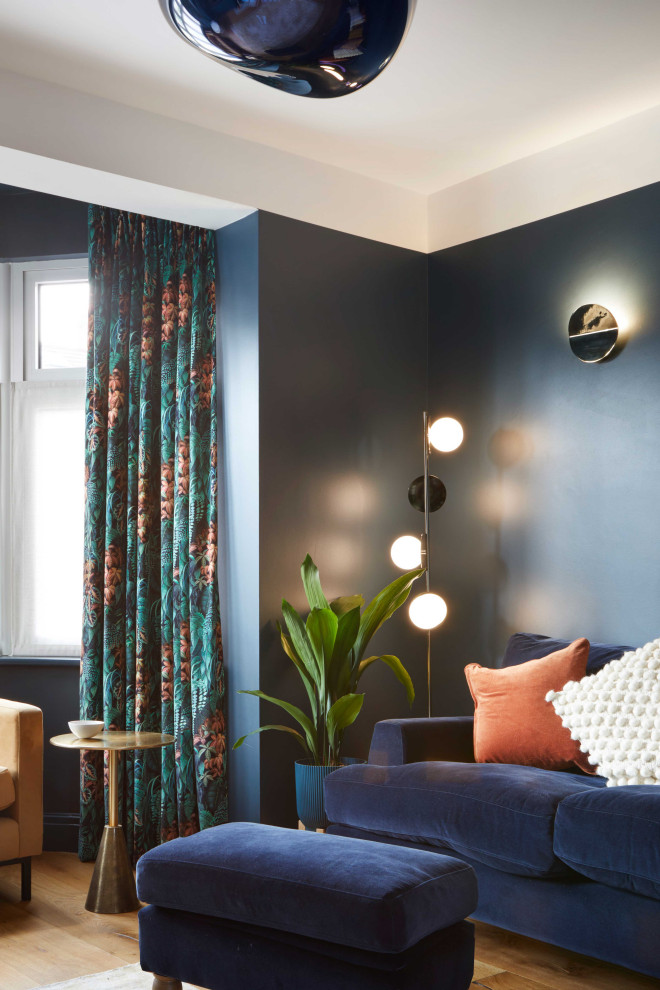 На фото: большая изолированная гостиная комната:: освещение в современном стиле с синими стенами, паркетным полом среднего тона, стандартным камином, фасадом камина из дерева и разноцветным полом с