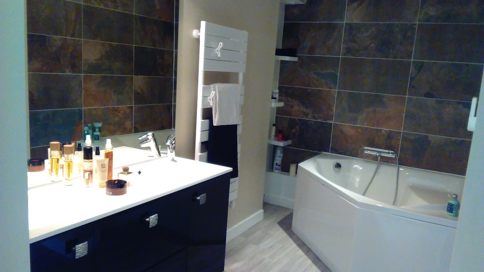 Idée de décoration pour une salle de bain principale design de taille moyenne avec des portes de placard noires, une baignoire d'angle, un carrelage marron, un mur beige, un sol en linoléum, un lavabo de ferme et un carrelage de pierre.