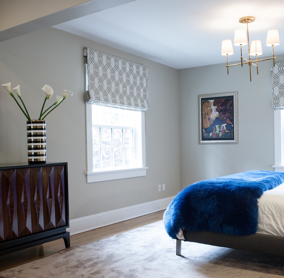 This is an example of a mid-sized guest bedroom in New York with beige walls and medium hardwood floors.