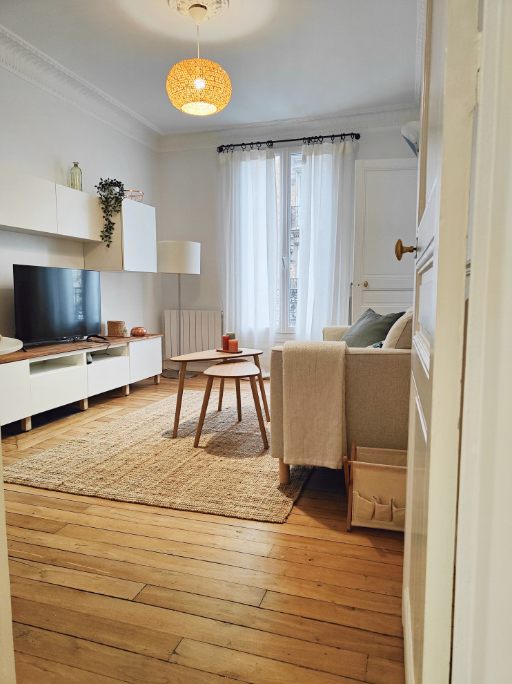 Inspiration for a small scandinavian living room in Paris with white walls, light hardwood flooring and a freestanding tv.