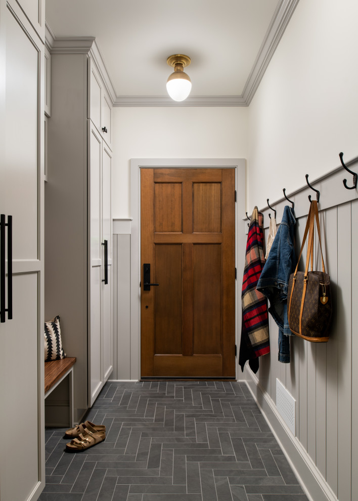 Photo of a mid-sized transitional mudroom in Burlington with grey walls, porcelain floors, a single front door, a dark wood front door, grey floor and decorative wall panelling.