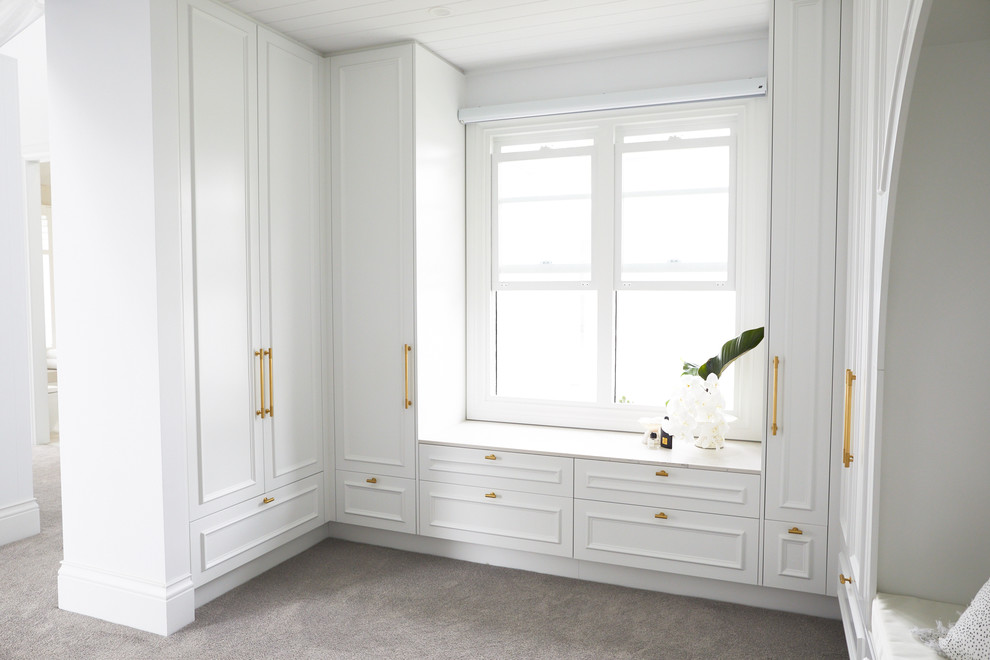 Inspiration for a large beach style gender-neutral walk-in wardrobe in Sydney with beaded inset cabinets, white cabinets, carpet and grey floor.